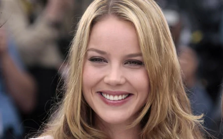 HD desktop wallpaper featuring a close-up of Australian actress and celebrity Abbie Cornish smiling with a blurred background.