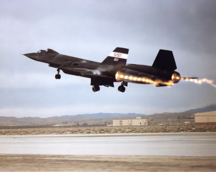 HD desktop wallpaper of a Lockheed SR-71 Blackbird military aircraft taking off with afterburners ignited against a desert airfield backdrop.