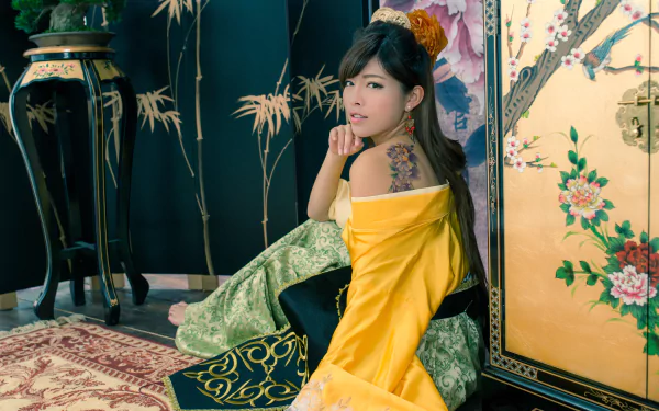 A Taiwanese woman in traditional costume and hair-dress, adorned with a colorful flower tattoo, poses gracefully against an ornate backdrop in this 4K Ultra HD wallpaper.