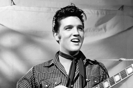 Black and white HD wallpaper featuring Elvis Presley, showcasing his charismatic smile while holding a guitar, capturing the essence of classic rock and roll.