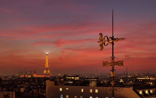 4K Ultra HD wallpaper of the Eiffel Tower glowing at twilight against a vibrant Paris sunset with city rooftops and an ornate weather vane in the foreground.