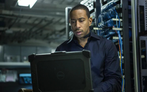 Ludacris as Tej in Furious 7, focused on a laptop amid a backdrop of server equipment, captures the high-stakes action of the Fast & Furious franchise. A dynamic HD wallpaper choice.