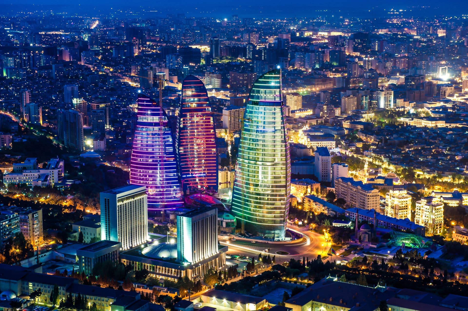 Nighttime view of the Flame Towers, iconic man-made skyscrapers in Baku, Azerbaijan, glowing vividly against the cityscape in 4K Ultra HD quality.