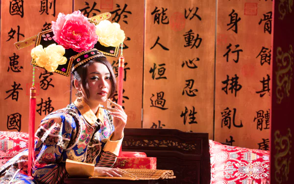 A Taiwanese woman in traditional Chinese costume poses in front of a scroll with Chinese calligraphy, styled as a 4K Ultra HD desktop wallpaper featuring Qián Fūrén.
