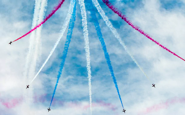 Military aircraft perform an air show, emitting vibrant red, white, and blue smoke trails against a cloudy sky in this striking 4K Ultra HD desktop wallpaper.