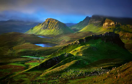 A breathtaking HD wallpaper showcasing the highlands of the Isle of Skye, Scotland, with lush green hills and a serene landscape under a dramatic sky.