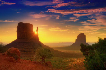 Stunning Arizona sunrise illuminating Monument Valley, with vibrant sunbeams spreading across the expansive desert sky, showcasing the beauty of nature in Utah. HD wallpaper.