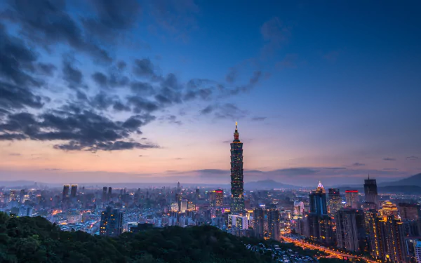 Nighttime cityscape of Taipei, Taiwan, featuring Taipei 101 skyscraper against a vibrant sky, captured in a high-definition landscape wallpaper.