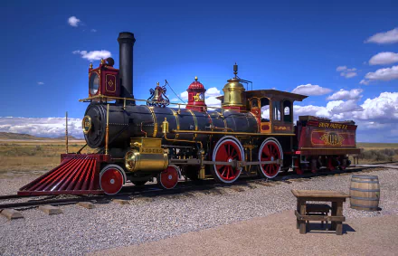 An HD desktop wallpaper showcasing a colorful and detailed vintage steam train on a railroad track, set against a clear blue sky with scattered clouds. The locomotive exudes a classic, nostalgic charm.