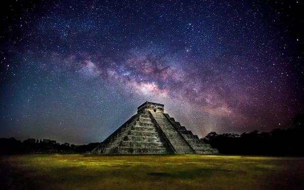 A stunning view of Chichen Itza in Yucatán, Mexico, illuminated under the Milky Way, showcasing the grandeur of this ancient pyramid against a starry backdrop.