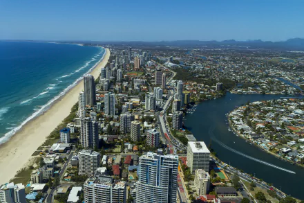 Aerial 4K Ultra HD view of the Gold Coast coastline in Queensland, Australia, featuring sandy beaches, ocean, and man-made urban development along the sea.