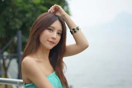 A Taiwanese Asian woman, model Julie Chang, smiles softly wearing a bracelet against a bokeh backdrop in Hong Kong, captured in 4K Ultra HD quality.