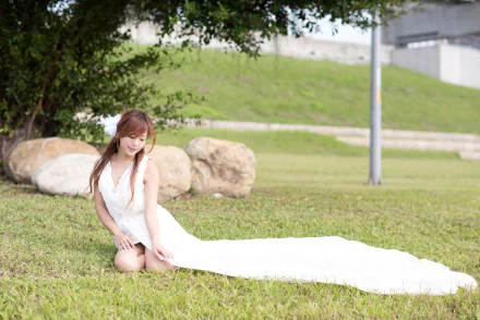 Taiwanese model kneeling on grass in a flowing white dress, captured as a 5K Ultra HD PC desktop wallpaper and background.
