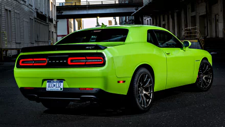 A vibrant green Dodge Challenger SRT Hellcat is parked in an urban alley, showcasing its sleek design and distinctive taillights in this HD desktop wallpaper.