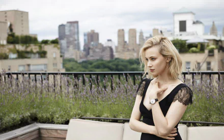 Canadian actress Sarah Gadon with blue eyes and blonde hair poses thoughtfully on a rooftop with a cityscape in the background.