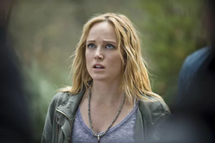 HD desktop wallpaper featuring Caity Lotz as seen in the TV show Arrow, capturing an intense moment with her expressive gaze and natural setting.