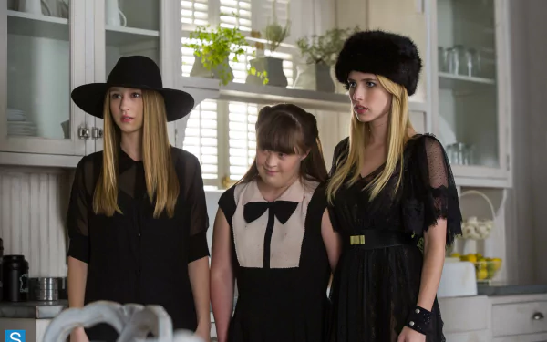 Three characters from American Horror Story: Coven stand in a stylish kitchen, dressed in dark clothing, exuding an air of mystery and intrigue in this 4K Ultra HD wallpaper.