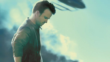 A high-definition wallpaper featuring Aaron Paul from the movie Need For Speed, capturing a dramatic moment against a smoky backdrop with a helicopter in the sky.