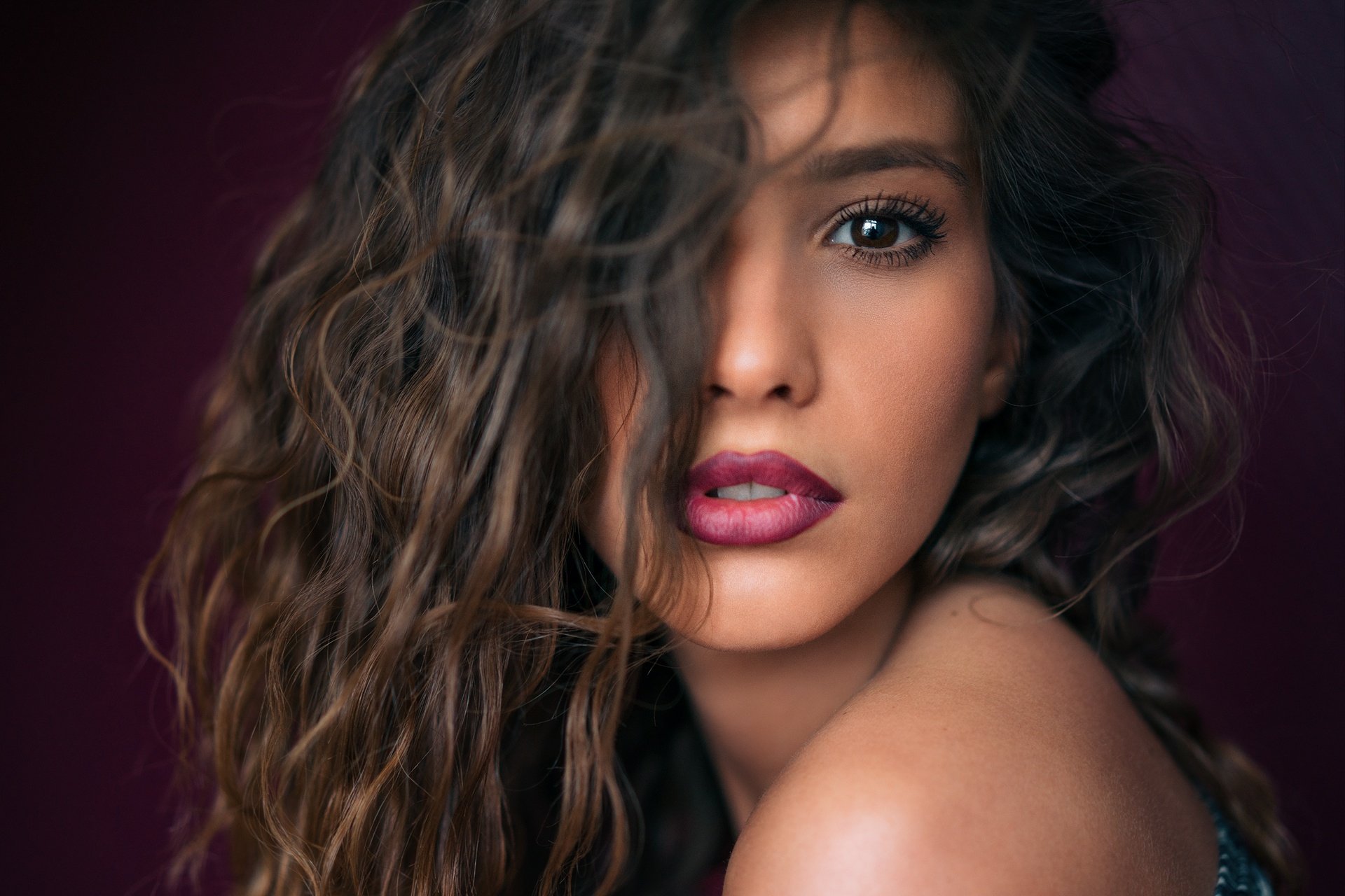 HD desktop wallpaper and background featuring a brunette woman with brown eyes and deep lipstick, showcasing her face with an intense, captivating look.