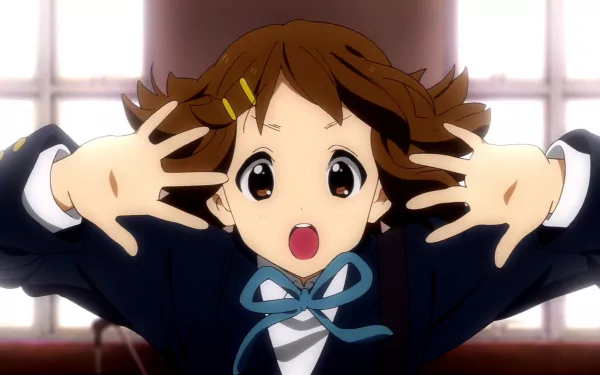 HD PC desktop wallpaper featuring Yui Hirasawa from the anime K-ON! in a lively pose with wide eyes and hands framing her face.