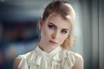 A striking blonde woman with blue eyes poses elegantly, featuring soft lighting that enhances her beauty. This HD image makes for an engaging desktop wallpaper or background.