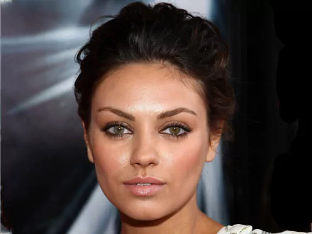 HD PC desktop wallpaper featuring a close-up portrait of celebrity Mila Kunis with a neutral expression and soft lighting.