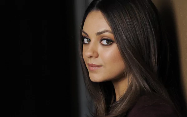 HD desktop wallpaper featuring a close-up portrait of celebrity Mila Kunis with soft lighting and a neutral background.
