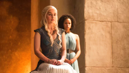 HD desktop wallpaper featuring Daenerys Targaryen (Emilia Clarke) from the TV show Game of Thrones, with Daenerys seated and another character standing behind her in a stone-walled setting.