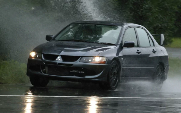A Mitsubishi Lancer Evolution speeds through rain, sending up a spray of water, captured in stunning detail for a high-definition PC desktop wallpaper.