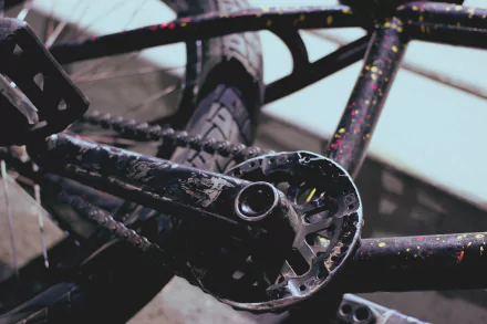 Close-up of a bicycle's crankset and tire, showcasing detailed textures and vibrant splashes of color. A dynamic 4K Ultra HD background for desktop use.