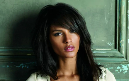 HD PC desktop wallpaper featuring a close-up portrait of a woman with dark hair against a textured greenish background, tagged with Emanuela De Paula.