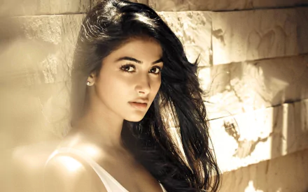 HD desktop wallpaper featuring Pooja Hegde, capturing her striking features against a soft, textured background.