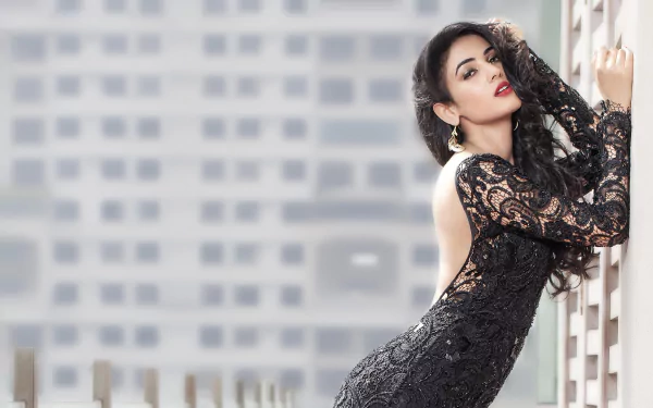 HD PC desktop wallpaper featuring celebrity Sonal Chauhan in a stylish black lace dress against a blurred modern architectural background.