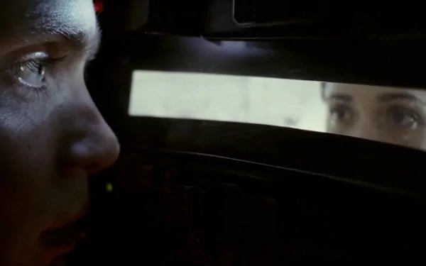 Close-up of two faces peering through a narrow hatch, cinematic still featuring the film's lead from Sunshine (2007); HD PC desktop wallpaper.