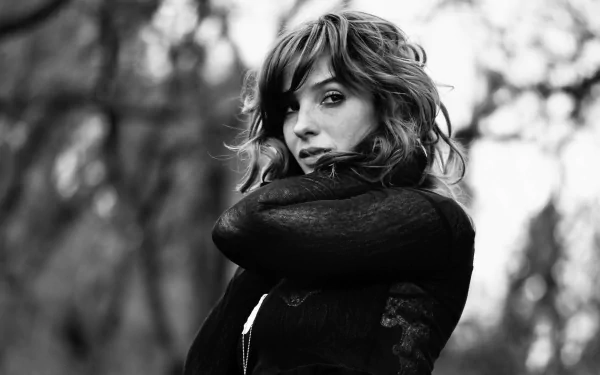 Black and white HD desktop wallpaper featuring woman Vica Kerekes with windswept hair, looking over her shoulder against a blurred outdoor background.
