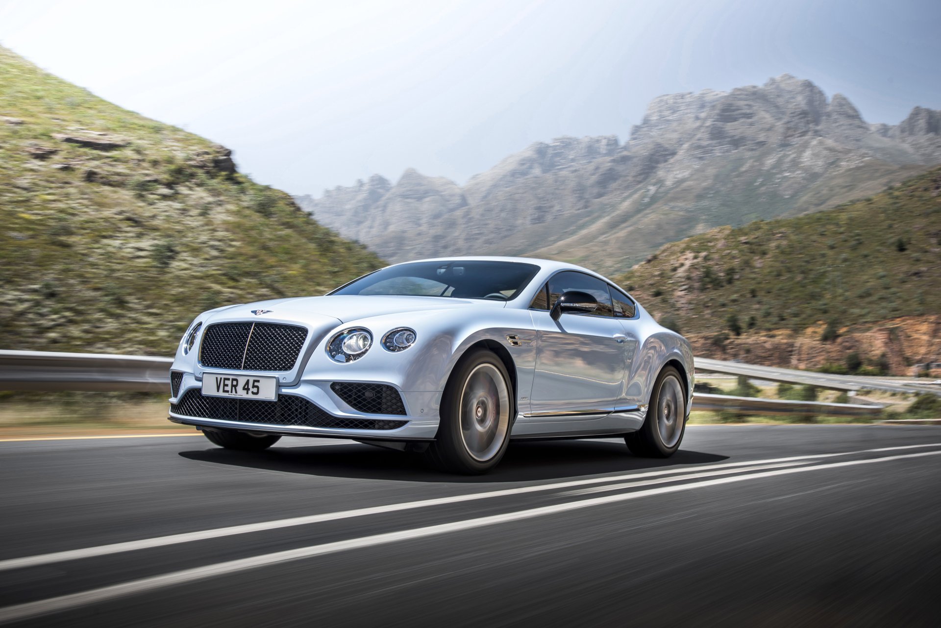 Silver Bentley Continental coupe on a winding mountain road — 4K Ultra HD PC desktop wallpaper background.