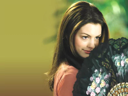 HD desktop wallpaper featuring Anne Hathaway from the movie The Princess Diaries, holding a black floral fan with a soft, blurred green background.