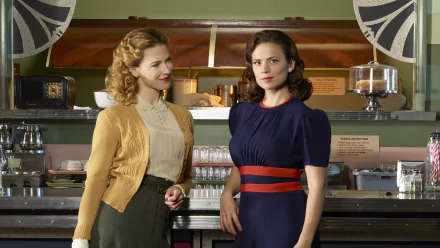 HD PC desktop wallpaper featuring Bridget Regan and Hayley Atwell from the TV show Agent Carter in a vintage diner setting.