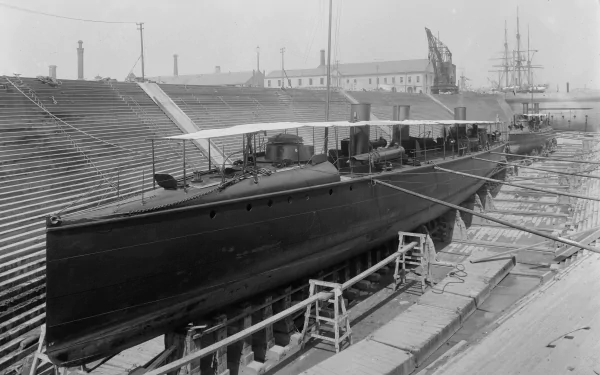 Black-and-white image of the military torpedo boat USS Ericsson (TB-2) in drydock, vintage naval scene — 2K Quad HD PC desktop wallpaper and background