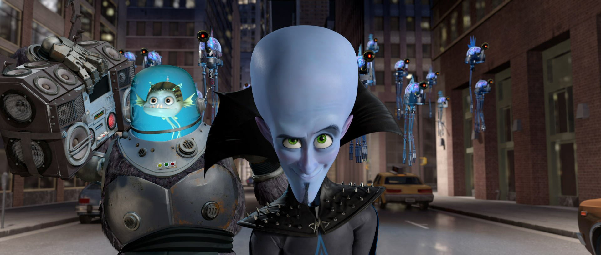 HD PC desktop wallpaper showing Megamind and his Minion from the movie Megamind — Megamind with a large blue head in front and the armored Minion in a dome behind on a city street.