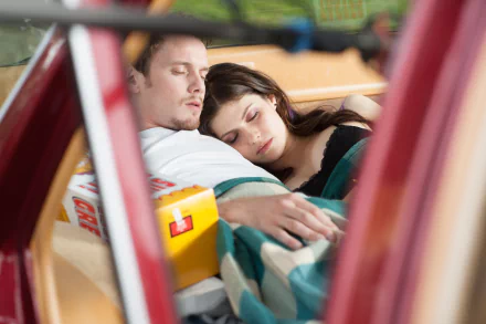 HD wallpaper featuring Anton Yelchin and Alexandra Daddario in a tender moment from the movie Burying the Ex, showcasing their intimate connection while resting together.
