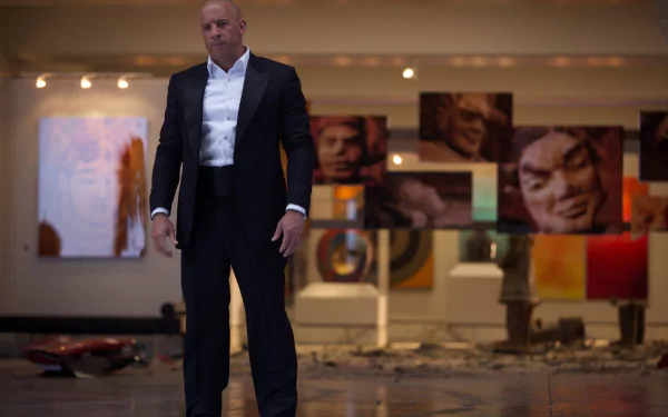 Dominic Toretto, portrayed by Vin Diesel, stands confidently in a sleek suit amidst modern art in this HD wallpaper from the movie Furious 7.
