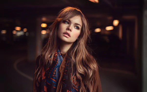 A high-definition desktop wallpaper featuring a woman in a parking lot, illuminated by soft lighting. The image captures the woman's contemplative expression and is tagged with Anastasiya Scheglova.