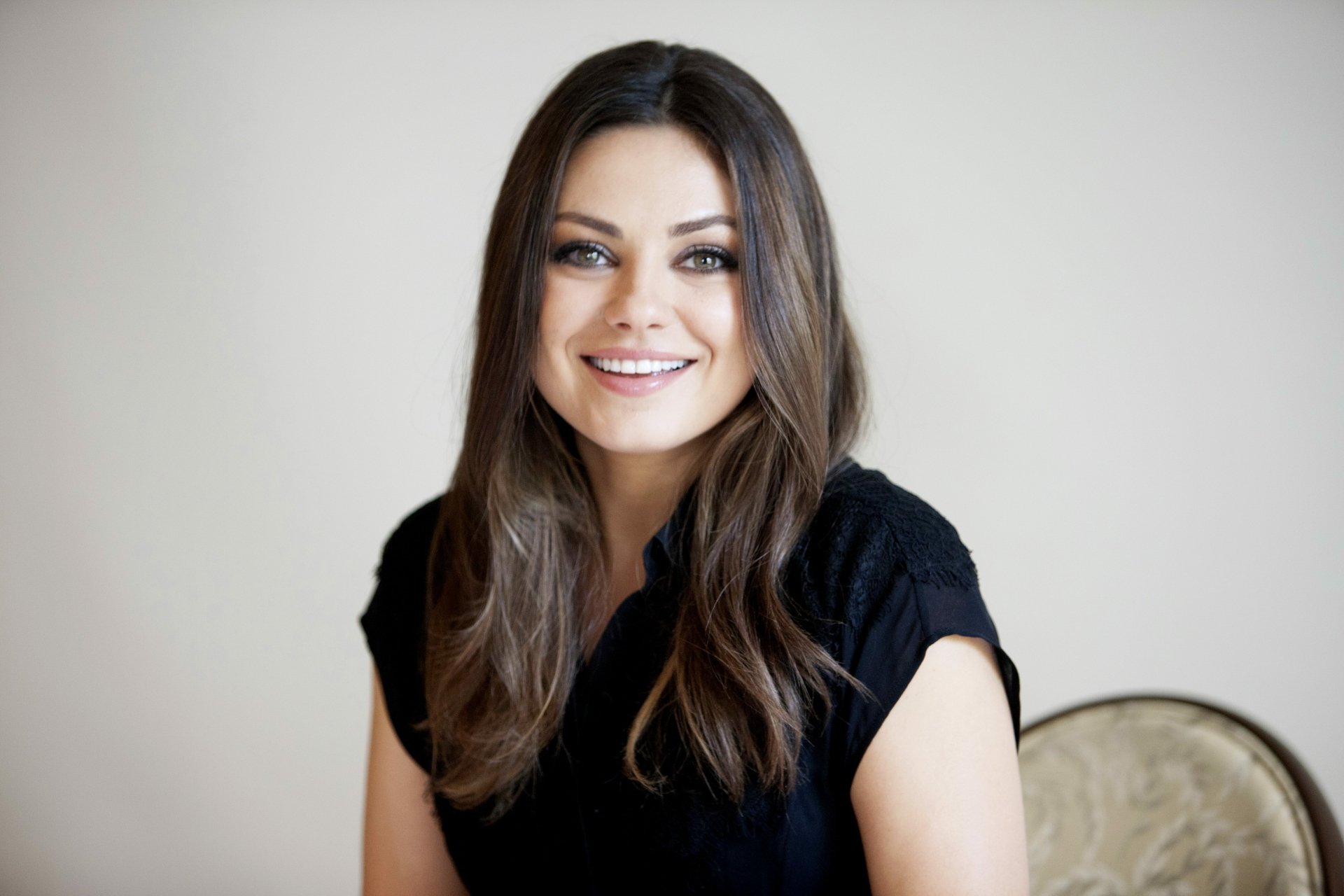 Portrait of celebrity Mila Kunis smiling, featured in a 4K Ultra HD PC desktop wallpaper and background.