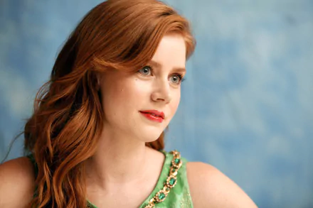 A stunning 4K Ultra HD wallpaper featuring actress Amy Adams, showcasing her captivating blue eyes and radiant red hair against a soft, blurred background.