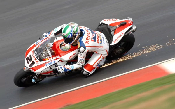 HD PC desktop wallpaper featuring a motorcycle racer leaning into a turn, sparks flying as the bike speeds along the track.