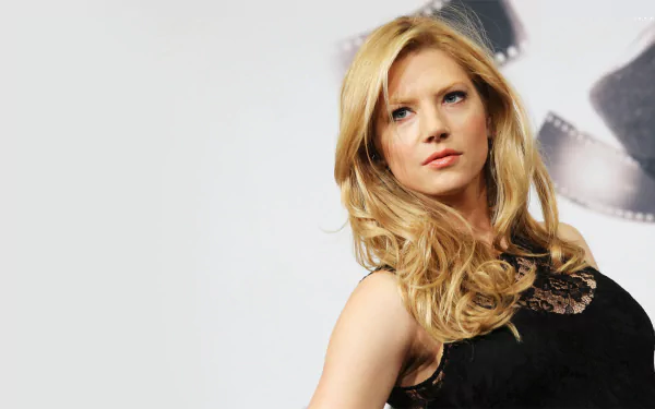 HD PC desktop wallpaper featuring celebrity Katheryn Winnick with flowing blonde hair and a black lace top against a soft gray background.