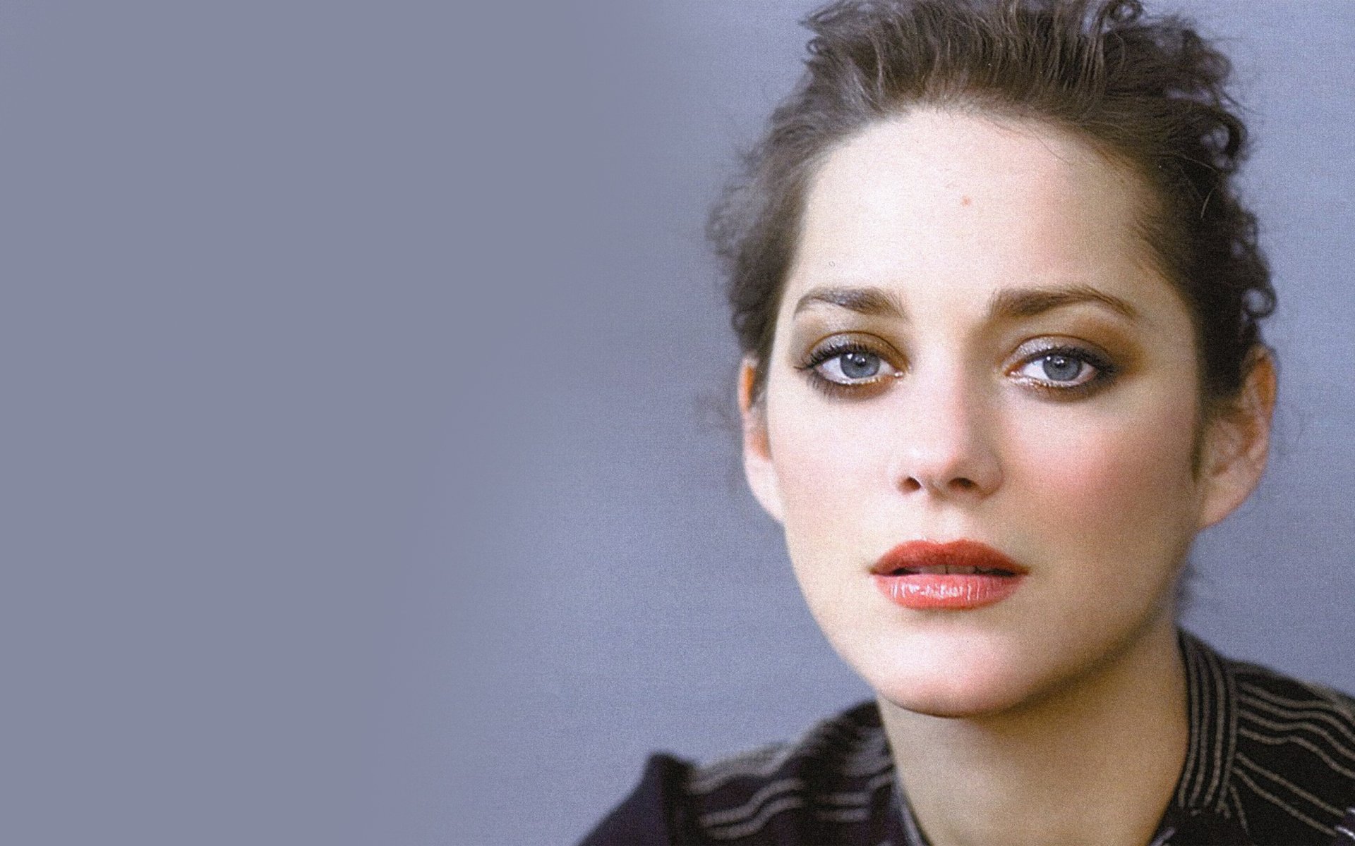 HD desktop wallpaper featuring a close-up portrait of celebrity Marion Cotillard against a soft purple-gray background.