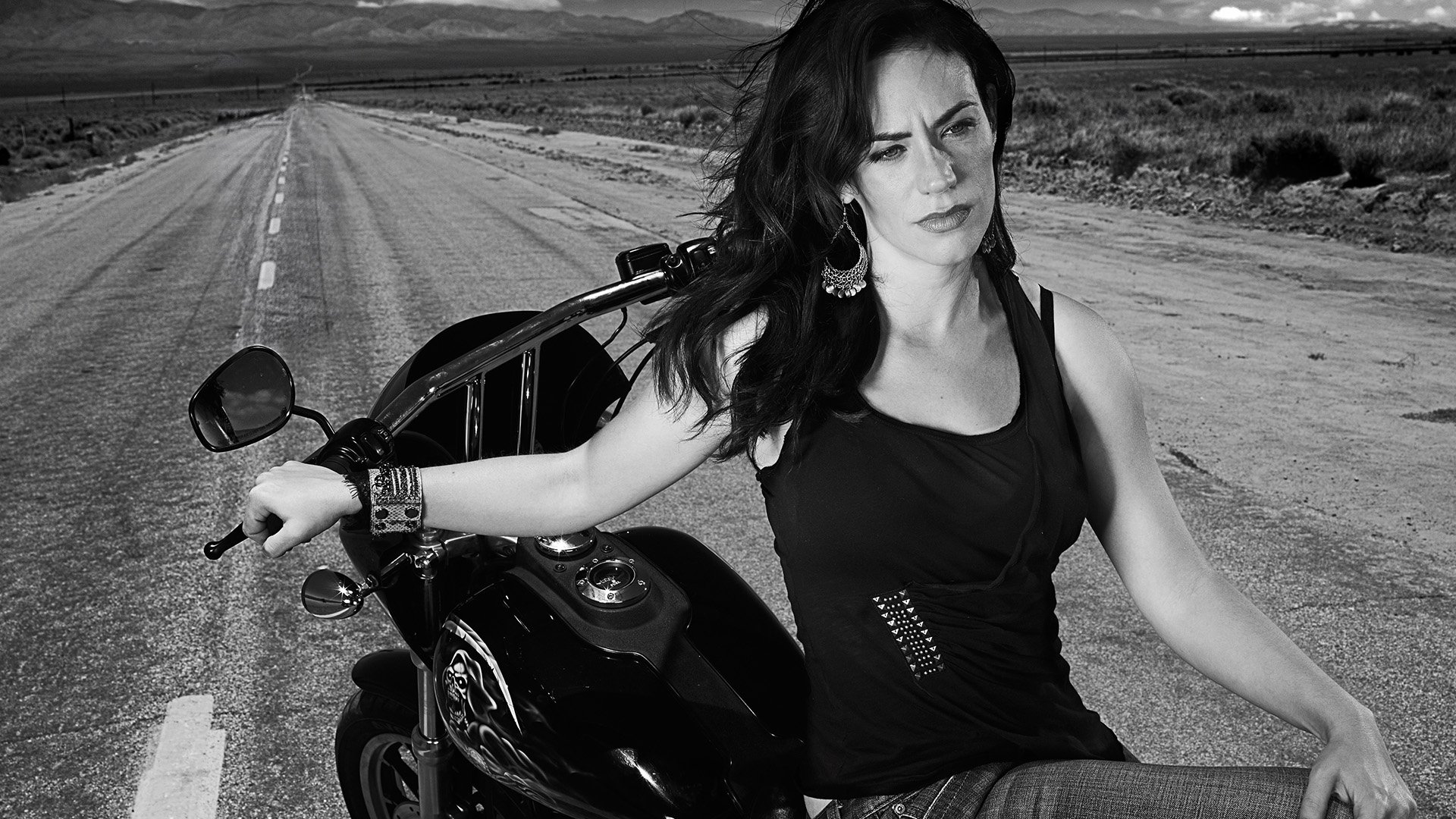 HD PC desktop wallpaper featuring a black-and-white image of a woman leaning on a motorcycle from the TV show Sons of Anarchy.
