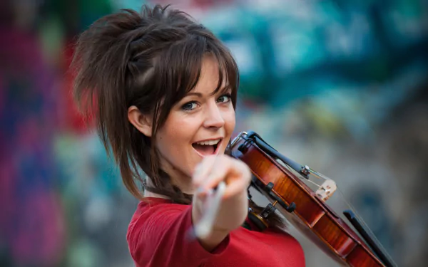 HD PC desktop wallpaper featuring musician Lindsey Stirling holding a violin, set against a vibrant, colorful background.